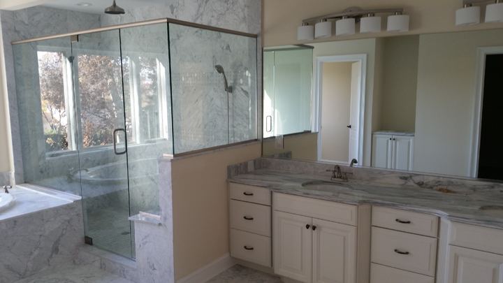 Spa bath with shower glass and frameless vanity mirror